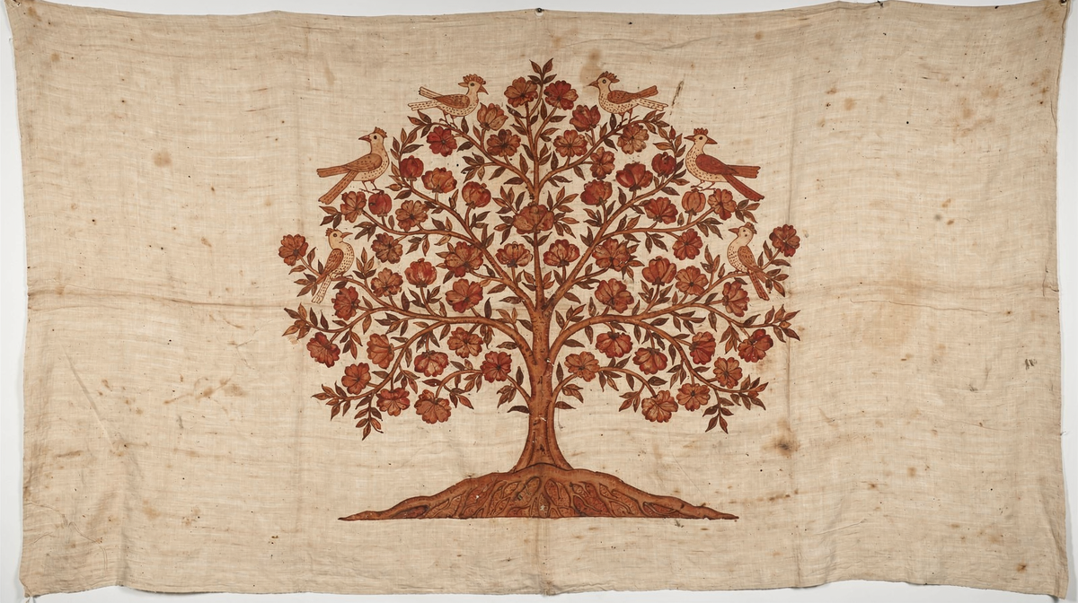 A palampore flowering tree of life rising from a small hill, branches heavy with fruit and perched birds, hand-drawn in madder red and iron brown on cream cotton